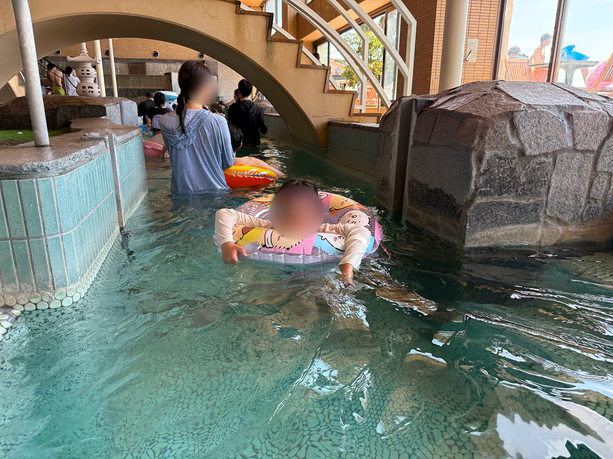 龍宮城スパホテル三日月 流れる温泉プールで泳ぐ様子